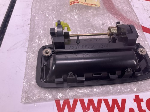 Buiten handvat links achteraan 